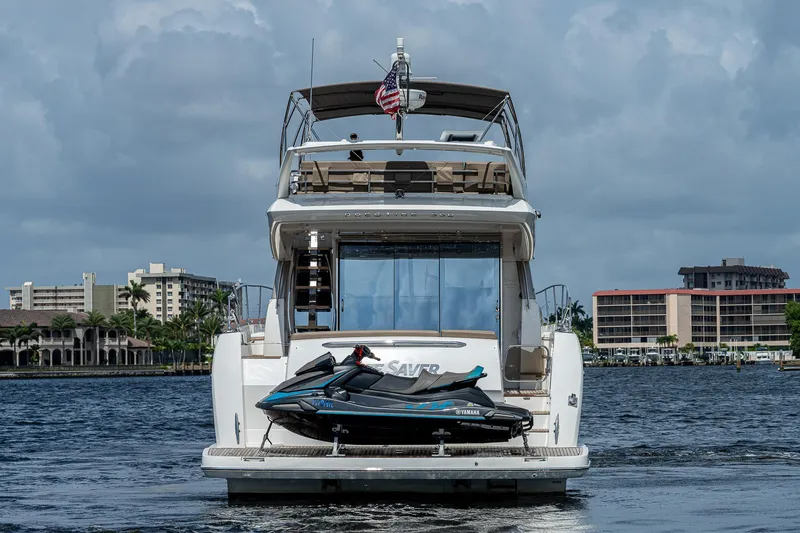Slide: The Image of Luxury 2014 Prestige 550 yacht with jet ski on deck, docked in scenic marina. - 3