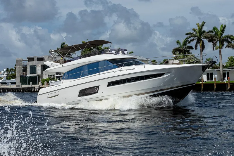 Slide: The Image of Luxury 2014 Prestige 550 yacht cruising on water near palm trees and modern homes. - 30