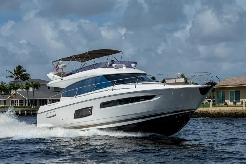 Slide: The Image of 2014 Prestige 550 yacht cruising on water under cloudy sky. - 36