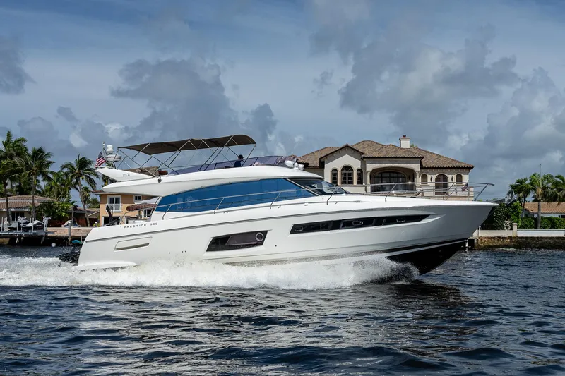 Slide: The Image of Luxury 2014 Prestige 550 yacht cruising near waterfront mansion under cloudy sky. - 39