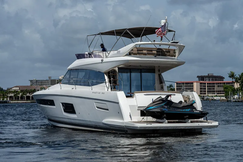 Slide: The Image of Luxury 2014 Prestige 550 yacht with jet ski, cruising on a calm waterway. - 4