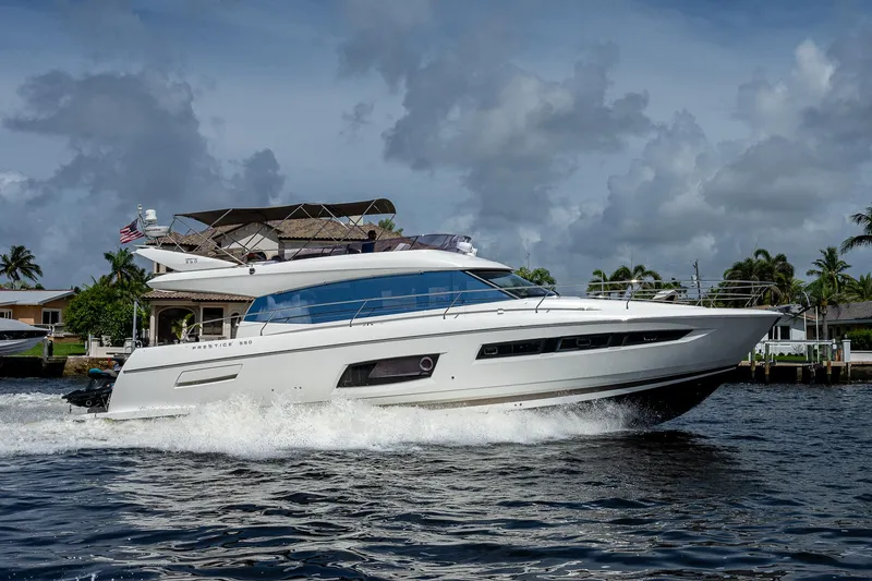 Slide: The Image of 2014 Prestige 550 yacht cruising on a sunny day with palm trees in the background. - 40