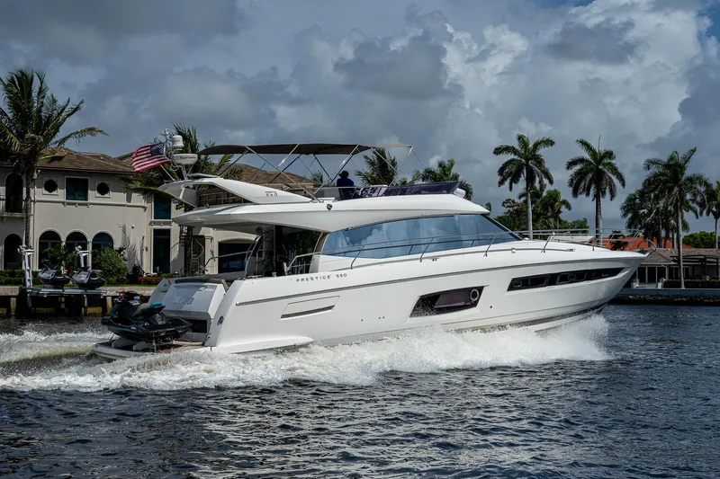 Slide: The Image of Luxury 2014 Prestige 550 yacht cruising near waterfront homes and palm trees. - 41
