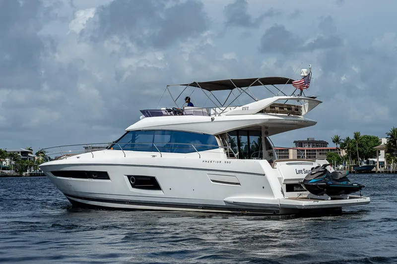 Slide: The Image of Luxury 2014 Prestige 550 yacht cruising on a calm waterway under a cloudy sky. - 6