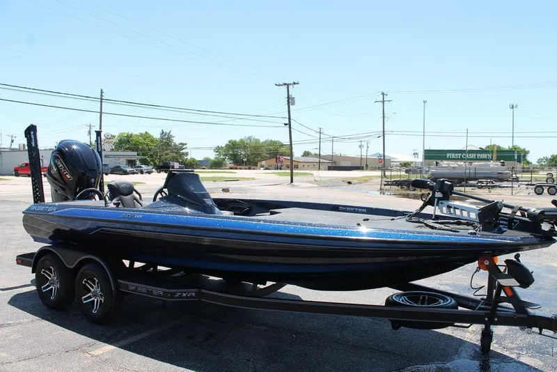 Slide: The Image of 2025 Skeeter ZXR20 bass boat on trailer in parking lot. - 3