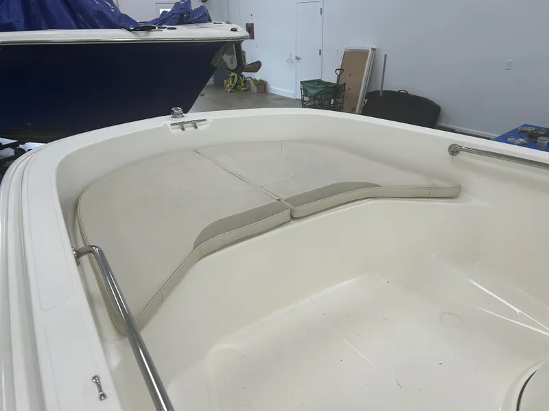 Slide: The Image of 2020 Boston Whaler 160 Super Sport interior with cushioned seating in a showroom. - 4