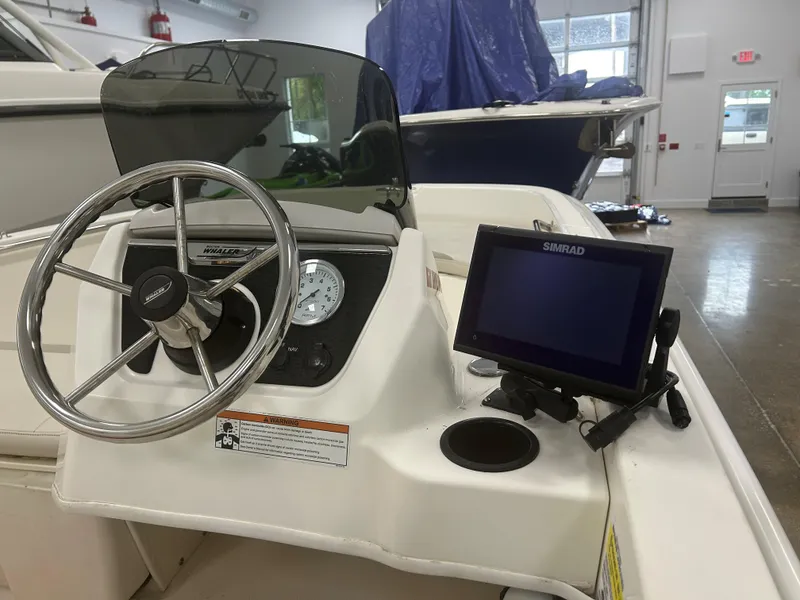 Slide: The Image of 2020 Boston Whaler 160 Super Sport dashboard with steering wheel and Simrad display. - 6