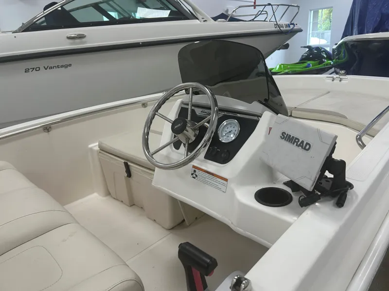 Slide: The Image of 2020 Boston Whaler 160 Super Sport boat interior with steering wheel and Simrad display. - 7