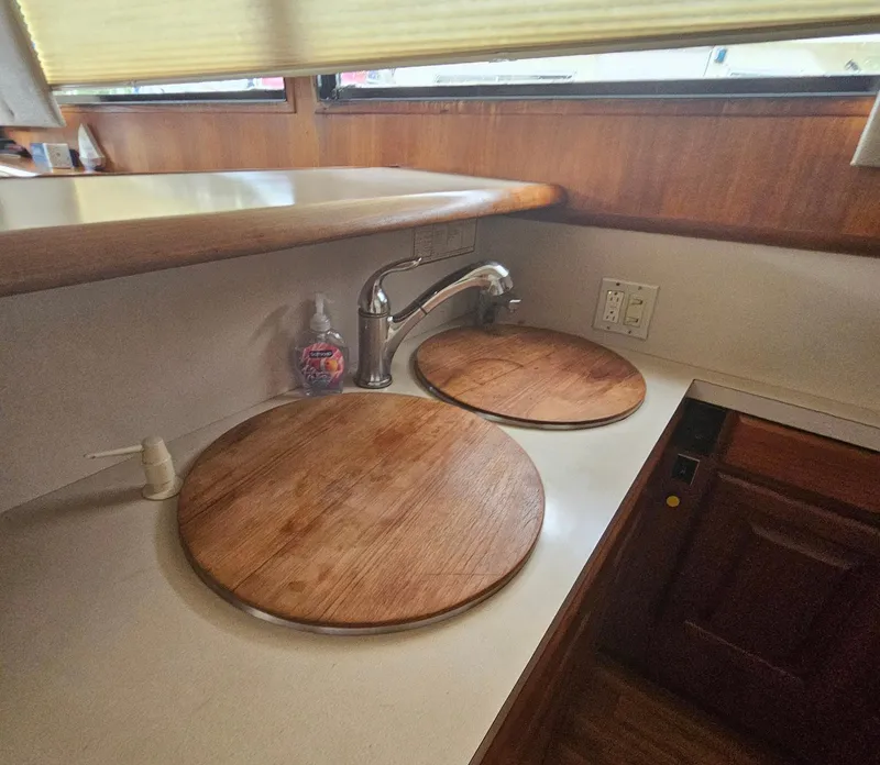 Slide: The Image of 1991 Viking 45 Convertible yacht kitchen with wooden sink covers and modern faucet. - 13