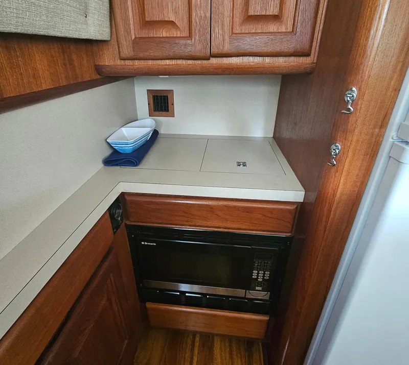 Slide: The Image of 1991 Viking 45 Convertible yacht kitchen with wooden cabinets and built-in microwave. - 14