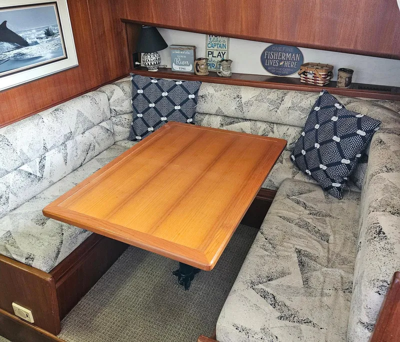 Slide: The Image of Cozy dining area in a 1991 Viking 45 Convertible yacht with patterned cushions and wooden table. - 17