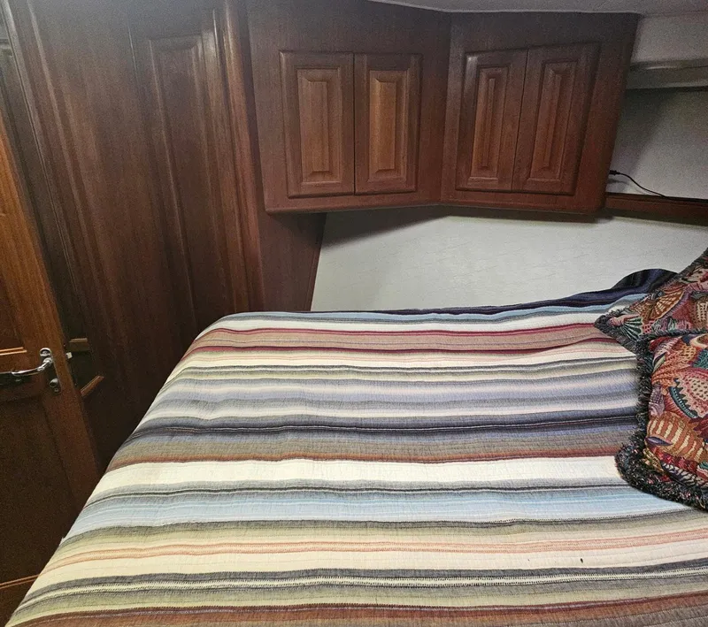 Slide: The Image of Cozy bedroom interior of 1991 Viking 45 Convertible yacht with striped bedding. - 19