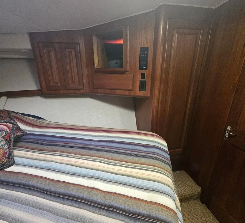 Slide: The Image of Interior cabin of 1991 Viking 45 Convertible with striped bedding and wooden cabinetry. - 21