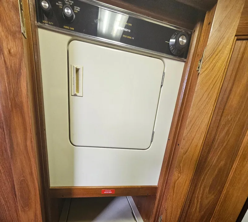 Slide: The Image of Laundry area inside a 1991 Viking 45 Convertible boat, featuring a built-in dryer. - 25