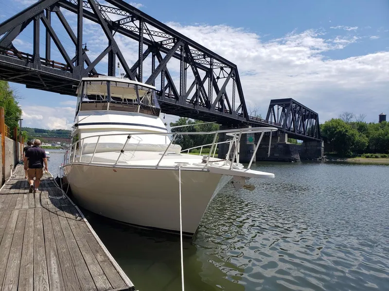 Slide: The Image of 1991 Viking 45 Convertible yacht docked near a steel bridge on a sunny day. - 28