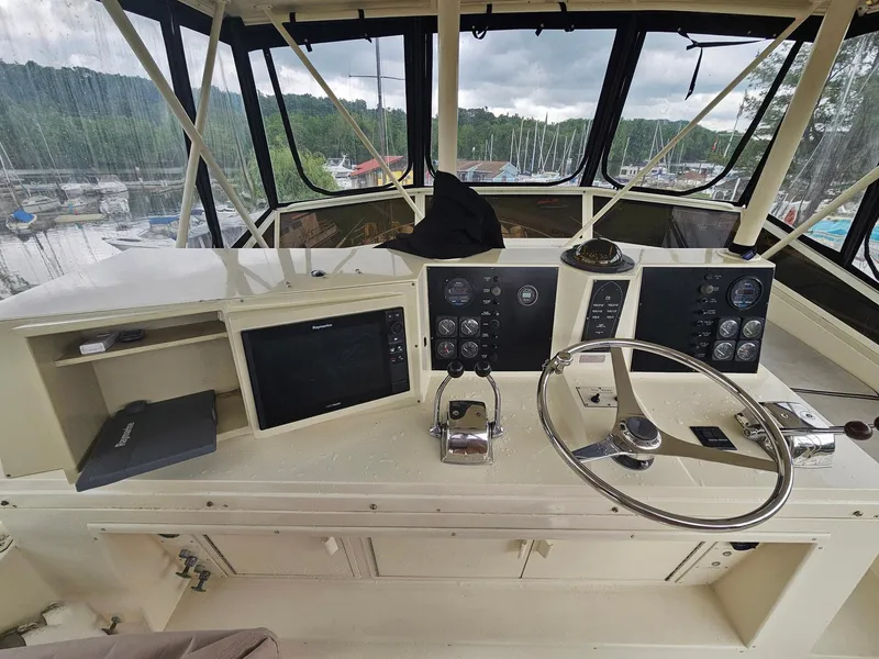 Slide: The Image of 1991 Viking 45 Convertible yacht helm with steering wheel and control panels. - 32