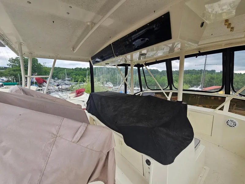 Slide: The Image of 1991 Viking 45 Convertible yacht interior with covered seating and marina view. - 37