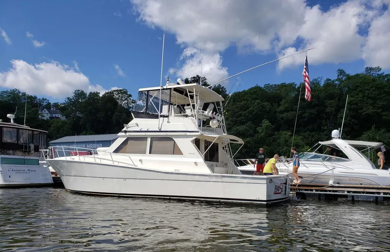 Slide: The Image of 1991 Viking 45 Convertible yacht docked, surrounded by people, with American flag, under blue sky. - 41