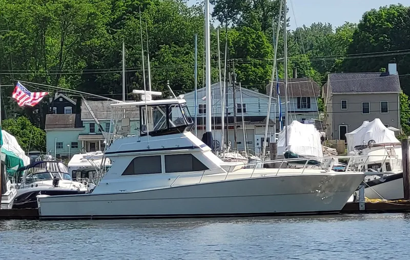Slide: The Image of 1991 Viking 45 Convertible yacht docked at a marina with American flag. - 42