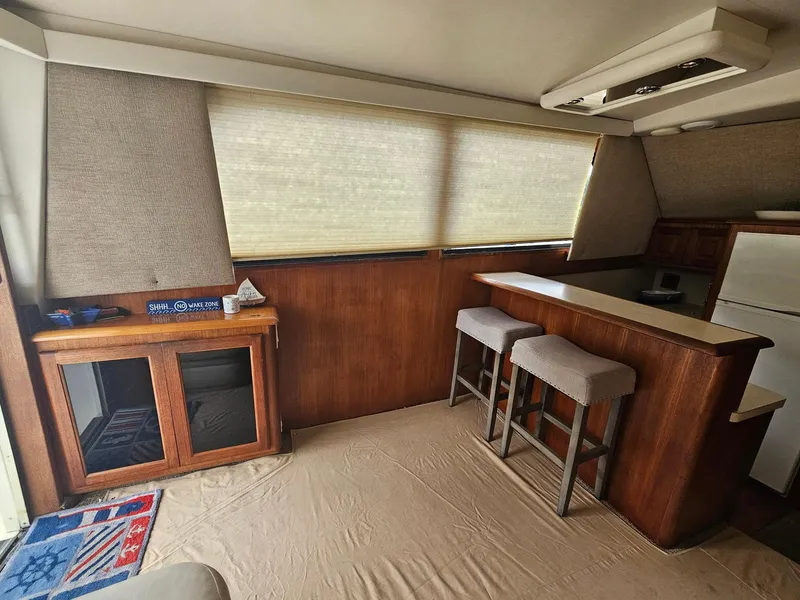 Slide: The Image of Interior of 1991 Viking 45 Convertible yacht with bar stools and wooden cabinetry. - 5