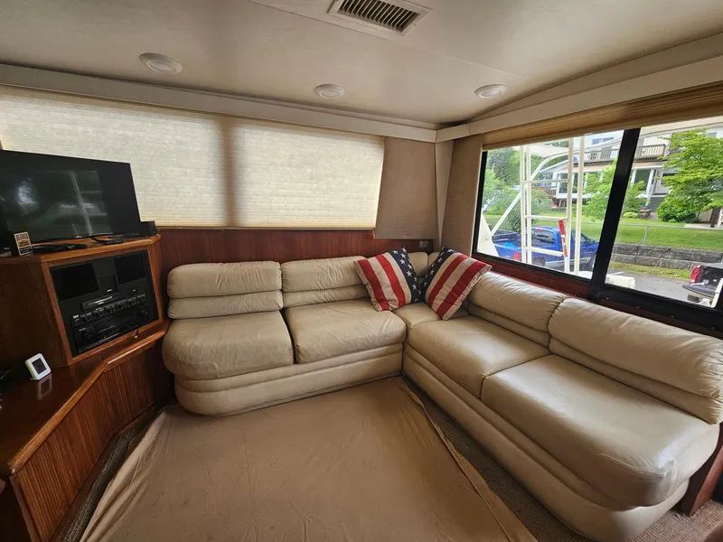 Slide: The Image of Interior of 1991 Viking 45 Convertible yacht with beige leather seating and American flag pillows. - 8