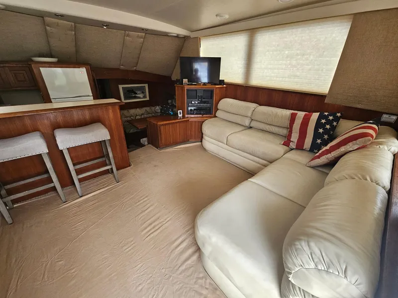 Slide: The Image of Interior of 1991 Viking 45 Convertible yacht with beige leather seating and American flag pillow. - 9