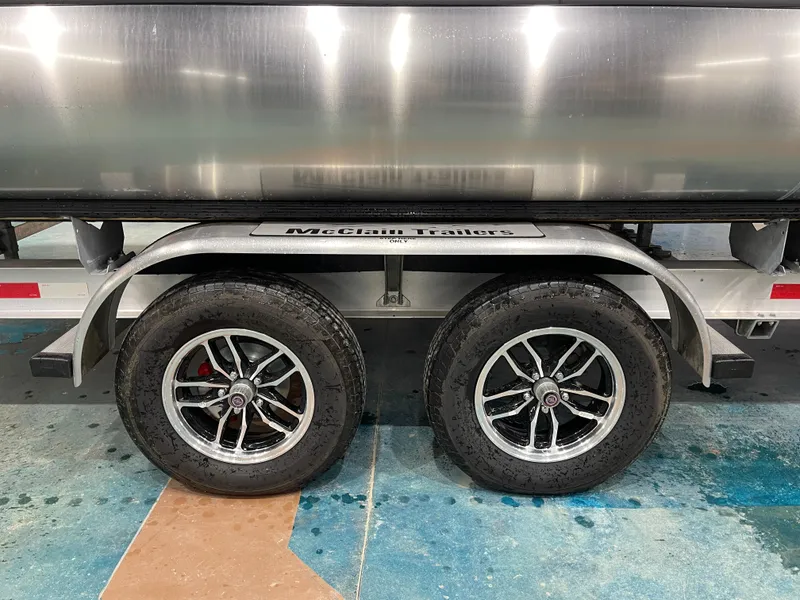 Slide: The Image of Trailer wheels of a 2025 Bennington 25SSRSE on McClain Trailers. - 12