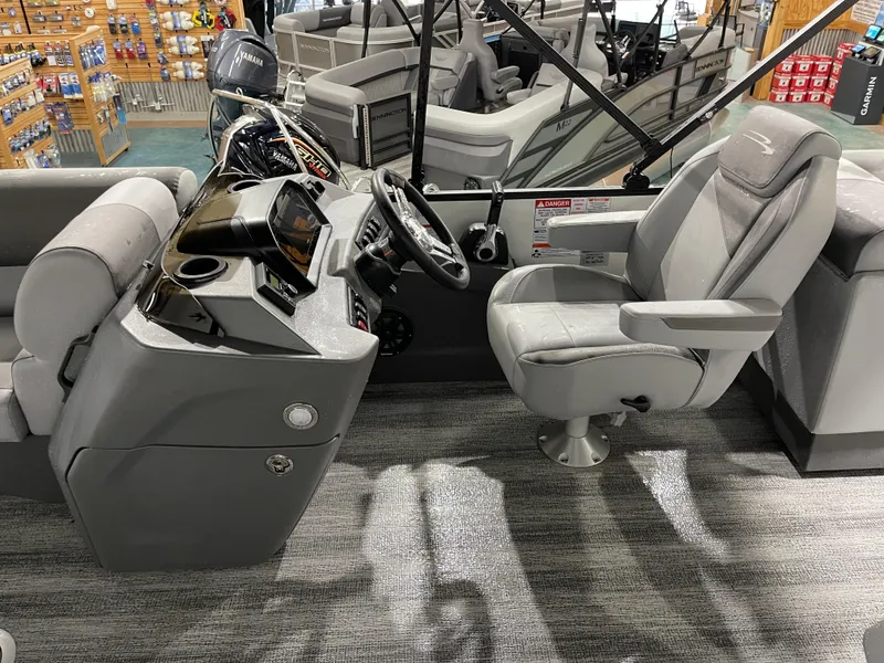 Slide: The Image of 2025 Bennington 25SSRSE boat interior with helm and captain's chair, showcasing modern design. - 19