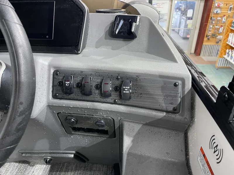 Slide: The Image of 2025 Bennington 25SSRSE boat dashboard with control switches and steering wheel. - 22