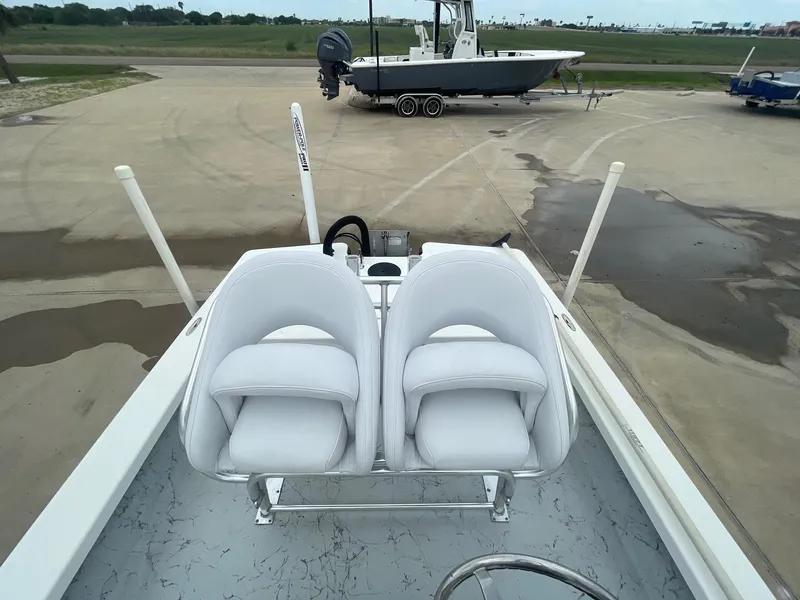 Slide: The Image of 2013 Majek 22 XTREME boat with white seats, parked on concrete near other boats. - 17