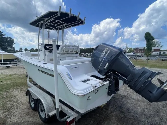 Slide: The Image of 2015 Sportsman Heritage 211 boat with Yamaha engine on trailer, parked outdoors. - 4