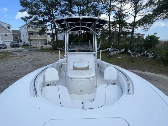 Slide: The Image of 2015 Sportsman Heritage 211 boat with seating, parked near trees and houses. - 7