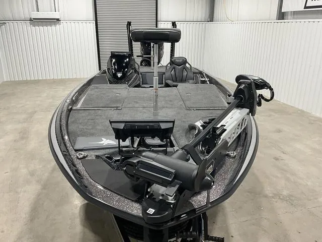 Slide: The Image of 2025 Skeeter FXR21L bass boat in a garage, featuring advanced fishing equipment. - 8