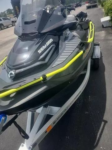 Slide: The Image of 2025 Sea-Doo Waverunner Explorer Pro on trailer, black with yellow accents, parked outdoors. - 23
