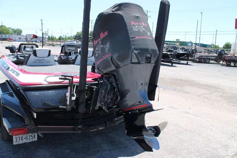 Slide: The Image of 2019 Skeeter FX21 LE boat with covered outboard motor in a parking lot. - 2