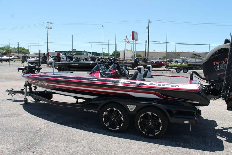 Slide: The Image of 2019 Skeeter FX21 LE bass boat on trailer in parking lot. - 4