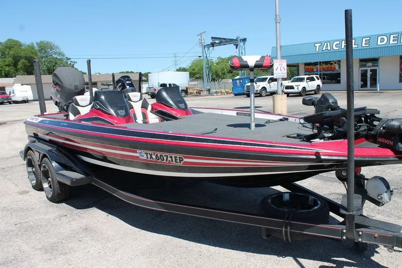 Slide: The Image of 2019 Skeeter FX21 LE bass boat in parking lot, red and black design, dual seats. - 5
