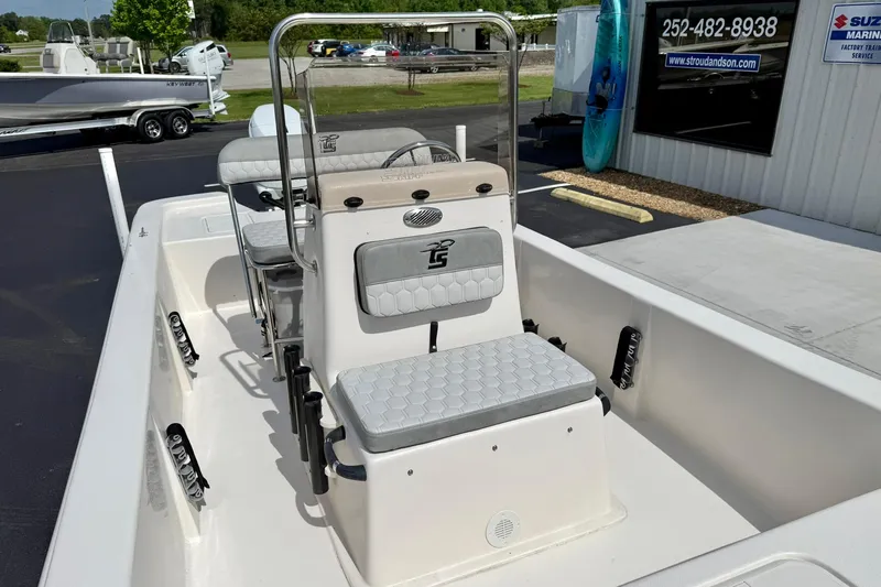 Slide: The Image of 2025 Carolina Skiff E18 JVX CC boat interior with seating and console, displayed outdoors. - 39