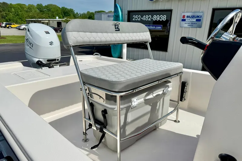 Slide: The Image of 2025 Carolina Skiff E18 JVX CC boat with cushioned seating and Suzuki outboard motor. - 45