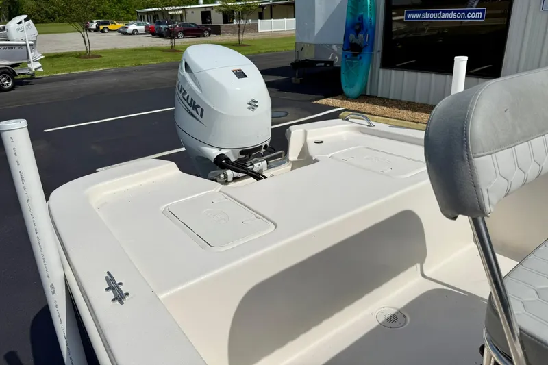 Slide: The Image of 2025 Carolina Skiff E18 JVX CC boat with Suzuki outboard motor, parked outdoors. - 49