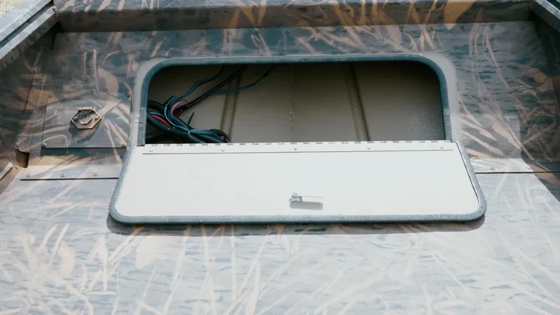 Slide: The Image of 2025 G3 Gator Tough 16 DK boat hatch with camo design and visible wiring. - 14