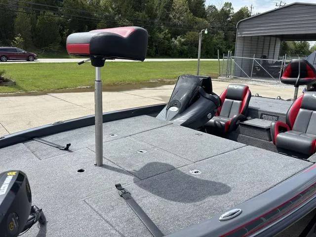 Slide: The Image of 2023 Phoenix 920 Elite II boat with seating and motor, parked outdoors. - 11