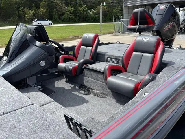 Slide: The Image of 2023 Phoenix 920 Elite II boat interior with red and gray seats, steering console, and motor. - 12