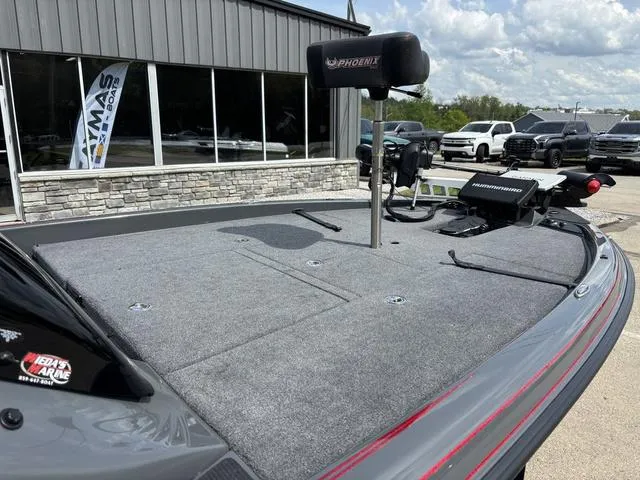 Slide: The Image of 2023 Phoenix 920 Elite II boat deck with fishing equipment, parked outside a showroom. - 7