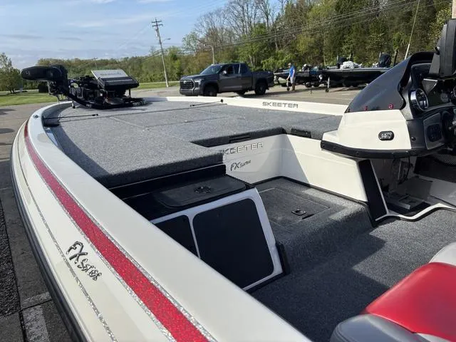 Slide: The Image of 2011 Skeeter FX21 bass boat with spacious deck and modern controls, parked outdoors. - 12