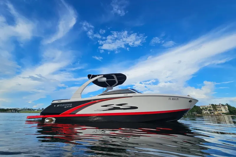 The Image of 2014 Four Winns H230SS boat on calm water under a vibrant blue sky. - 0