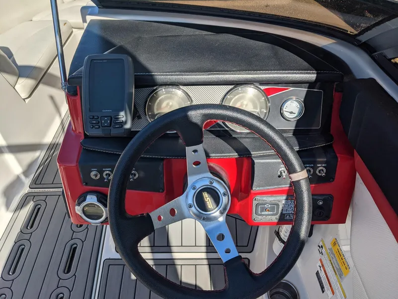 Slide: The Image of Steering wheel and dashboard of 2014 Four Winns H230SS boat, featuring gauges and controls. - 7