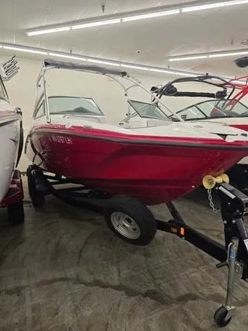 Slide: The Image of 2015 Yamaha AR210 boat in showroom, red exterior, on trailer. - 1