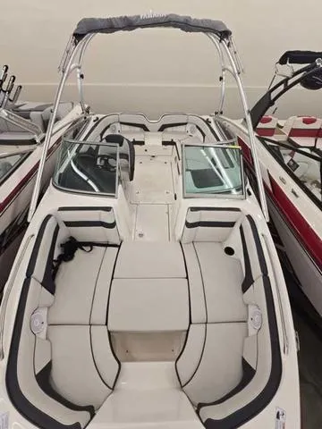 Slide: The Image of 2015 Yamaha Boats AR210 with sleek design and spacious seating in a showroom. - 17