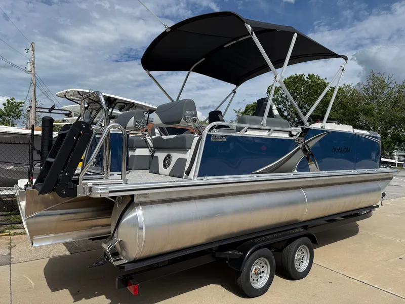 Slide: The Image of 2025 Avalon LSZ Quad Lounger Shift pontoon boat on trailer, featuring sleek design and canopy. - 10